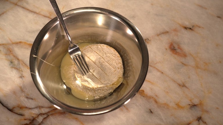 Gebackenen Camembert in eine Schüssel geben.