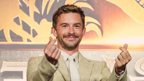 Jonathan Bailey zeigt Herz-Symbole bei der Asien-Premiere von „Jurassic World: Rebirth“.