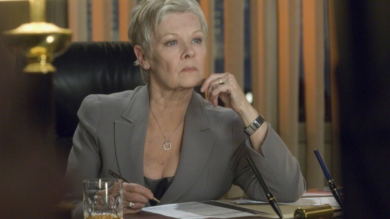 Judi Dench am Schreibtisch sitzend in "Casino Royale"