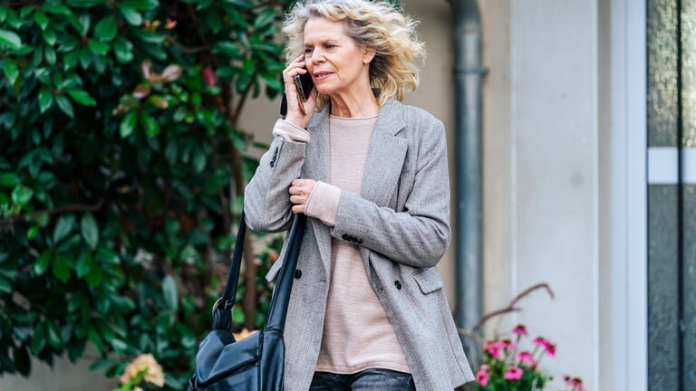 Kati (Christiane Bachschmidt) telefoniert vor dem Haus