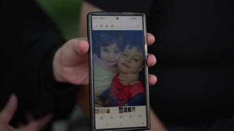 Eine Flüchtete aus Syrien zeigt das Bild ihrer Kinder auf einem Handy