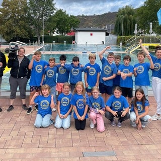 Schulklasse vor Schwimmerbecken im Freibad