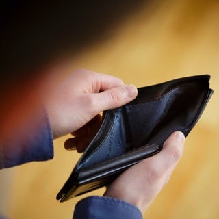 Ein Mann schaut in ein leeres Portmonnaie | Alles wird teurer – nur ein Bauchgefühl oder Tatsache?