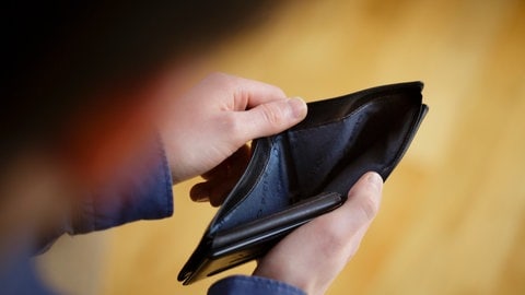 Ein Mann schaut in ein leeres Portmonnaie | Alles wird teurer – nur ein Bauchgefühl oder Tatsache?