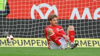 Stefan Posch (1. FSV Mainz 05) sitzt enttäuscht nach dem 3:4 gegen Leverkusen auf dem Rasen