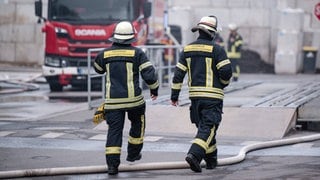 Zwei Feuerwehrleute am Einsatzort bei einem Brand am Wertstoffhof in Welgesheim