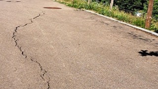 Bedrohliche Risse in der Straße am Rand eines Wohngebiets von Täferrot, die sich innerhalb kürzester Zeit auf bis zu vier Zentimeter Breite vergrößerten.