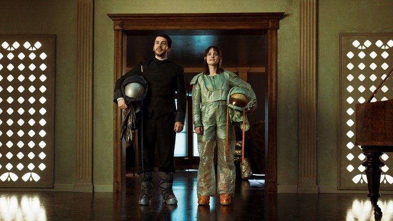 Vanessa Loibl (re.) als Weltraumhotelerbin Nia und David Brizzi (li.) als Androide Adam in der Serie „The Stardust Hotel“.