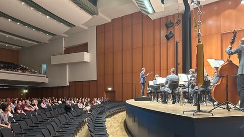 Dirigent Mathias Klocker leitet beim Dirigentenwettbewerb das Heeresmusikkorps Ulm.