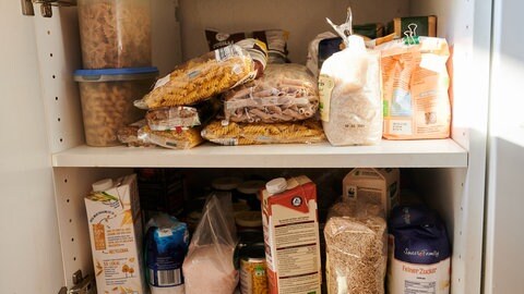 Notfallpaket bei Stromausfall: Vorräte im Schrank wie Reis, Mais und Milch. 