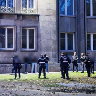 Mehrere Polizisten umzingeln am Stadthaus in Mainz eine Gruppe Männer, die einen Polizisten angegriffen haben soll.