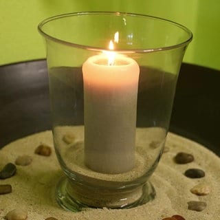 Eine brennende Kerze steht auf einem Tisch
