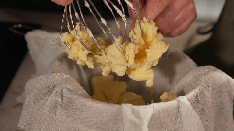 Butter in ein sauberes Tuch (Etamin) geben. 