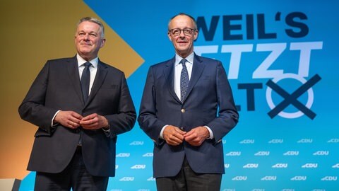Bundeskanzler Friedrich Merz (r, CDU) steht mit dem rheinland-pfälzischen Parteivorsitzenden Gordon Schnieder beim Landesparteitag der rheinland-pfälzischen CDU auf der Bühne. Die Delegierten wählten Schnieder zum Spitzenkandidaten für die Landtagswahl 2026.