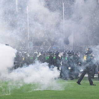 Beim DFB-Pokalspiel SV Waldhof Mannheim - 1. FC Kaiserslautern stehen Polizisten im Mannheimer Carl-Benz-Stadion vor dem Fanblock des SV Waldhof Mannheim.