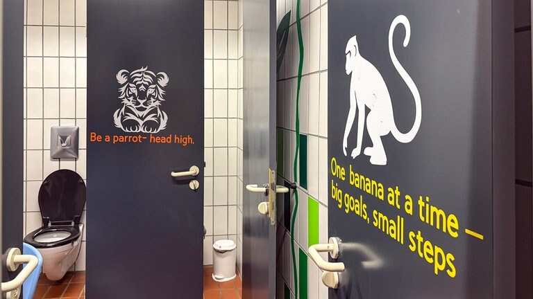 Ein Affe und ein Tiger-Sticker kleben an den Türen der Klokabinen. Darunter witzige Sprüche. Schüler des Carlo-Schmid-Gymnasiums in Tübingen übernehmen die Gestaltung ihrer Schultioletten selbst.