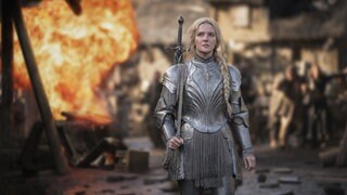 Die Schauspielerin Morfydd Clark steht als Galadriel in der Serie "Die Ringe der Macht" vor einem Feuer