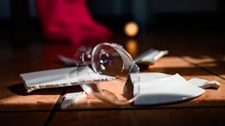 Ein zerbrochenes Weinglas und ein kaputter Teller liegen in einer Küche auf dem Boden: Über Gewalt in Partnerschaften sprechen nur wenige offen – oft aus Scham oder Angst. Das macht das Thema für die Forschung schwierig