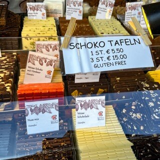 Preisschild an einer Auslage mit vielen bunten Tafeln Schokolade auf dem Schokomarkt chocolART in Tübingen.