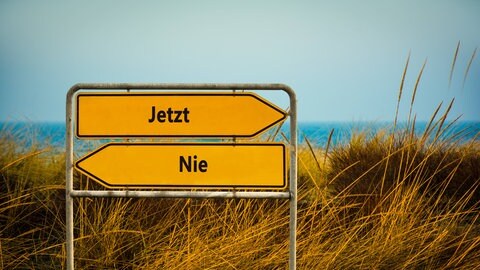 Wegweiser für den direkten Weg zum Jetzt versus Nie. Oft klemmt der Startknopf in unserem Gehirn. Das Resultat: Prokrastination.
