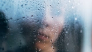 Junge verschwommen hinter einer regennassen Fensterscheibe: Kinder, die sexuelle Gewalt in der Familie erleben, sind ihr oft schutzlos ausgeliefert. Umso wichtiger ist, dass das Umfeld genau hinschaut und mutig handelt.IMAGO  Addictive Stock