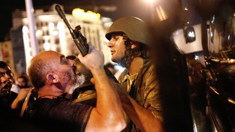 Ein Mann packt den Gewehrlauf eines Soldaten: Türkische Polizisten nehmen am 16. Juli 2016 auf dem Taksim-Platz in Istanbul türkische Soldaten fest. 