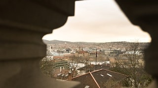 Wolken die leicht gelb gefärbt sind bringen Saharastaub mit, fotografiert durch eine Mauer an einem Aussichtspunkt über der Stuttgarter Innenstadt. Gefährlich ist dieses Naturphänomen nicht - nur sollte man manche Sachen beachten.