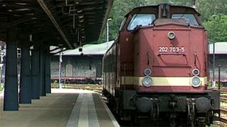 Eine Lok fährt in einen Bahnhof ein