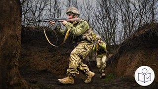 Der russische Angriffs·krieg gegen die Ukraine hat im Februar 2022 begonnen. Das Foto zeigt einen ukrainischen Soldaten mit dem Gewehr im Anschlag. Rechts das SWR Logo für Leichte Sprache. 