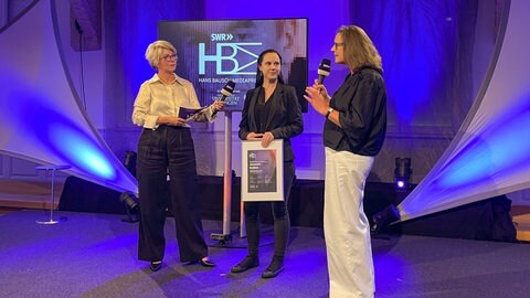 Jeanette Kollien (mitte) bei der Preisübergabe zusammen mit Moderatorin Stefanie Germann (links) und Prof. Martina Thiele, Uni Tü (rechts). Jeanette Kollien ist Preisträgerin des Hans Bausch Mediapreis 2025.