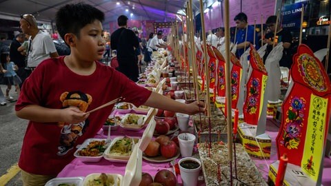 Chinesen bereiten Opfergaben für die Toten beim Festival der Hungergeister in Kuala Lumpur vor.