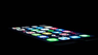 Ein Smartphone leuchtet im Dunkeln. Mit Finanz-Apps haben Betrüger eine Frau aus Waldmohr (Kreis Kusel) um mehr als 87.000 Euro gebracht.