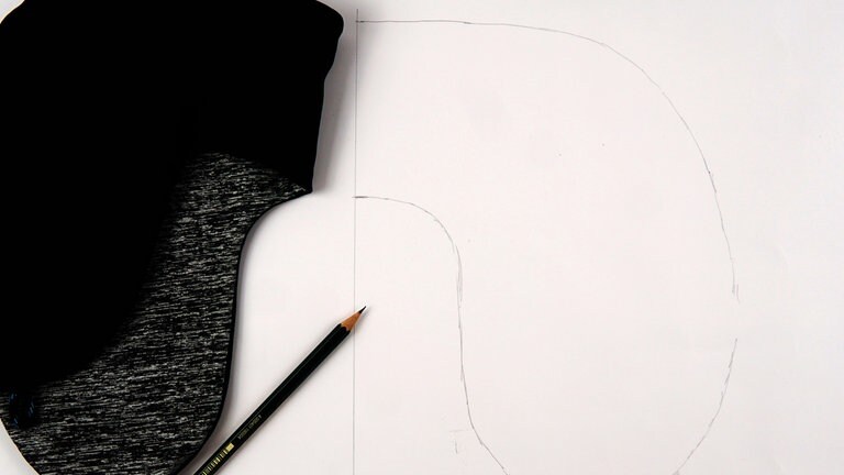 Den alten Bezug glatt auf das Schnittpapier legen und die Kontur mit Bleistift abzeichnen.