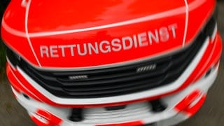 Rettungswagen mit der Aufschrift Rettungsdienst - in Cochem hat ein führerloses Auto eine Frau und ein Kleinkind angefahren.