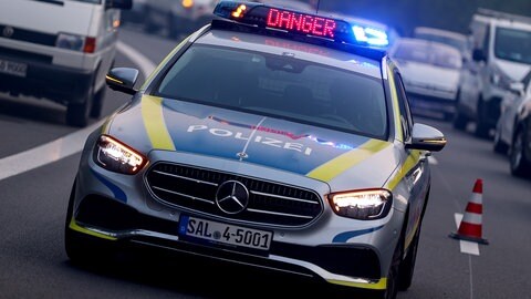 Ein Polizeiwagen steht auf einer Straße. Auf dem Dach des Autos ist ein Schild mit der Aufschrift: " DANGER" (Symbolbild).