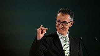 Cem Özdemir (Grüne), Spitzenkandidat Landtagswahl Baden-Württemberg, macht bei der Wahlparty seiner Partei eine Geste und reckt den kleinen Finger der rechten Hand hoch.