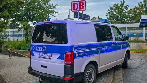 Ein Einsatzfahrzeug der Polizei steht an einem Bahnhof. Auf der Fahrt zwischen Offenburg und Karlsruhe ist ein Mitarbeiter der DB-Sicherheit nach einem Streit aus dem fahrenden Zug gestürzt