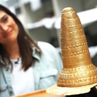 Der goldene Hut von Schifferstadt und Reporterin Meike Rathsmann im Hintergrund.