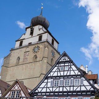 Turm der evangelischen Stiftskirche und Fachwerkhäuser am Marktplatz in Herrenberg
