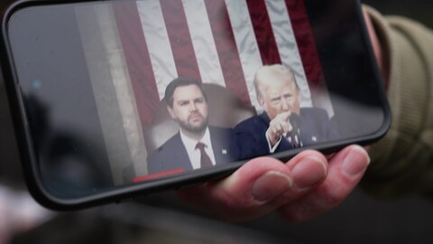 Trump auf dem Handy in typischer machtpose mit ausgestrecktem Finger