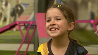 Letizia, 7 Jahre alt, grinst in die Kamera.