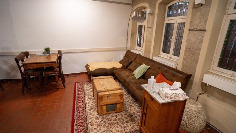 Ein Sofa, Tisch und Teppich bieten Sitzgelegenheiten im Hoffnungshaus.