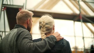 Ehepaar steht vor dem Rohbau eines Stelzenhaus