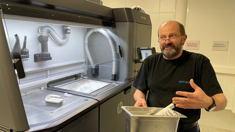 In der 3D-Druckerei säubert Guido Vollmer fertige Teile.