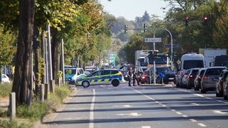 Einsatzkräfte sichern die Reanimation in der Wiesbadener Äppelallee vor Blicken von Gaffern ab.