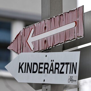 Ein Schild weist den Weg zu einer Arztpraxis