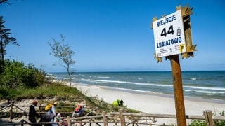 Strandschild in Lubiatowo mit Atomstopp-Aufkleber, wenige Kilometer vom geplanten Bau eines Kernkraftwerks in der Gemeinde Choczewo entfernt. Touristen und Sommerhausbewohner protestieren, doch die alteingesessene Bevölkerung erhofft sich wirtschaftlichen Aufschwung vom ersten Atomkraftwerk Polens.