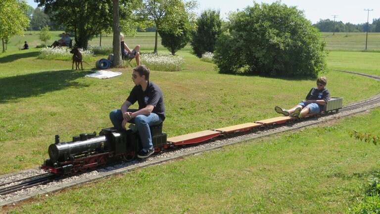 Diese beiden Jungs waren unermüdlich unterwegs. Endlich mal Eisenbahn fahren bis es dunkel wird. Während der eine für das Feuer im Kessel sorgt, ruht sich der andere eine Runde aus.