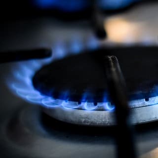 Eine blau leuchtende Gasflamme an einem Herd. Der Preis für Gas in Deutschland ist 2022 hoch wie lange nicht. Was tun bei einer Preiserhöhung? Lohnt sich der Wechsel zum Grundversorger? 