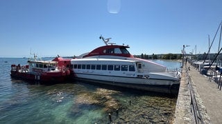 Eine Katamaran-Fähre steht am Hafen in Konstanz an einer Kaimauer. 